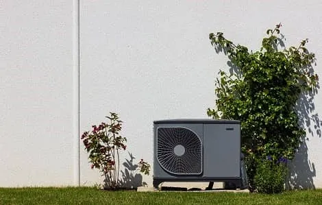 Heatpump outside home with greenery