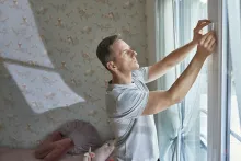 Wiser Window and Door Sensor - a man fits the door sensor