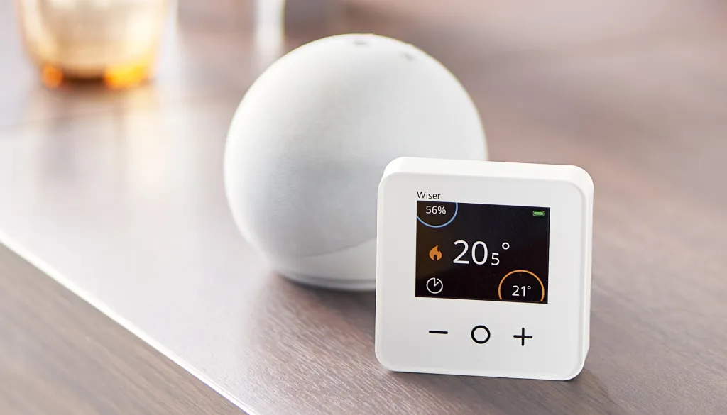Wiser's smart thermostat next to an Amazon Alexa Dot - Wiser is compatible with Alexa and Google Assistant voice controls