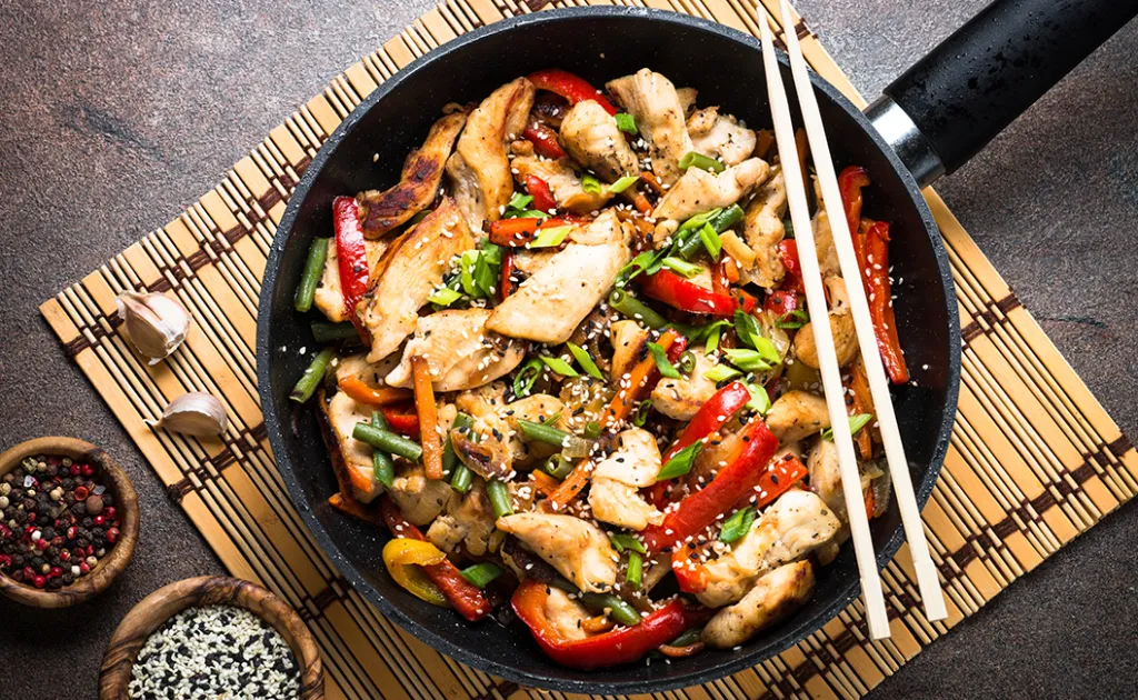 A top-down photo of a stir fry being prepared, a good way to use up spare ingredients to reduce food waste