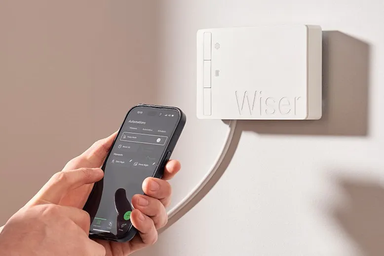 Wiser 2nd Generation Smart Heating Hub installed next to a boiler, with an installer setting up the smart heating app